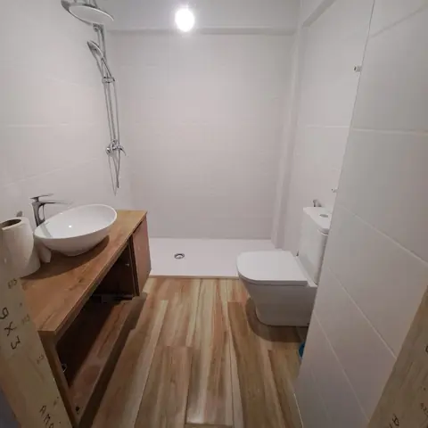 Baño terminado con plato de ducha y suelo efecto madera
